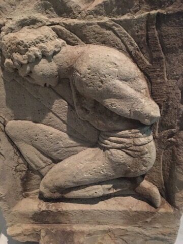 Gefangener Mann auf Steinskulptur